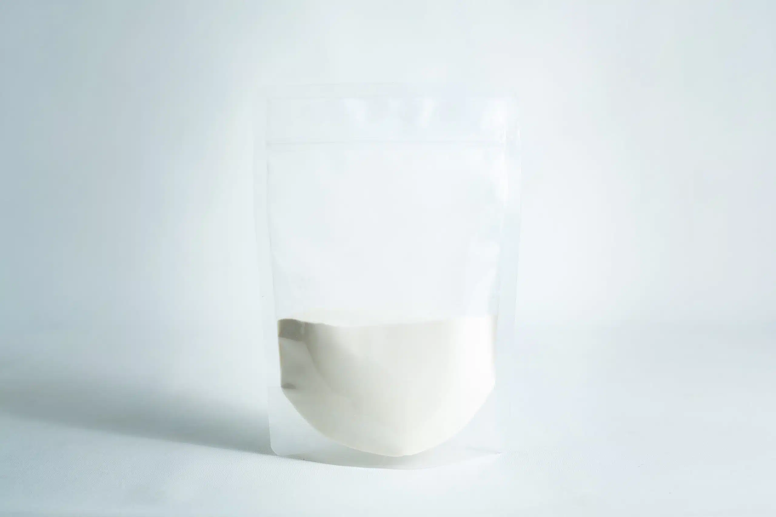 A clear resealable pouch, half-filled with Agar Mix MYAG Antibacterial Malt Extract Yeast powder, sits on a white surface against a light background.
