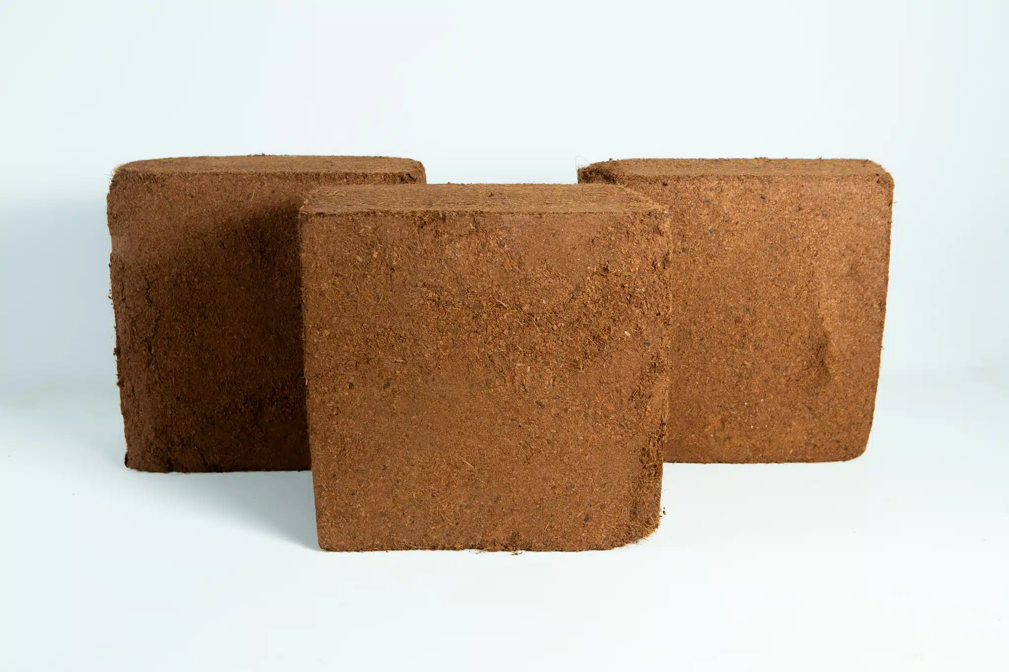 Three brown, square Coco Coir Block 5 kg (60L), Washed of Salts, Buffered RHP grade blocks are arranged against a plain white background.