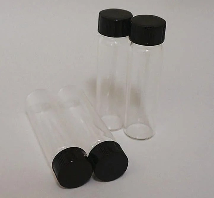 Ten empty 50ml Clear Borosilicate Reagent Lab Glass bottles with black screw caps, arranged with some standing upright and some lying down.