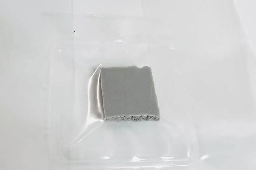 Manure Based All in One Mushroom Grow Bag |1kg 6 A small, square piece of grey material on a clear plastic tray against a white background.