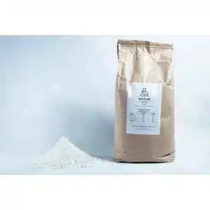A bag labelled ROOTLAB, containing Brown Rice Flour 5kg Organic Food Grade, stands beside a mound of fine white powder on a white background.