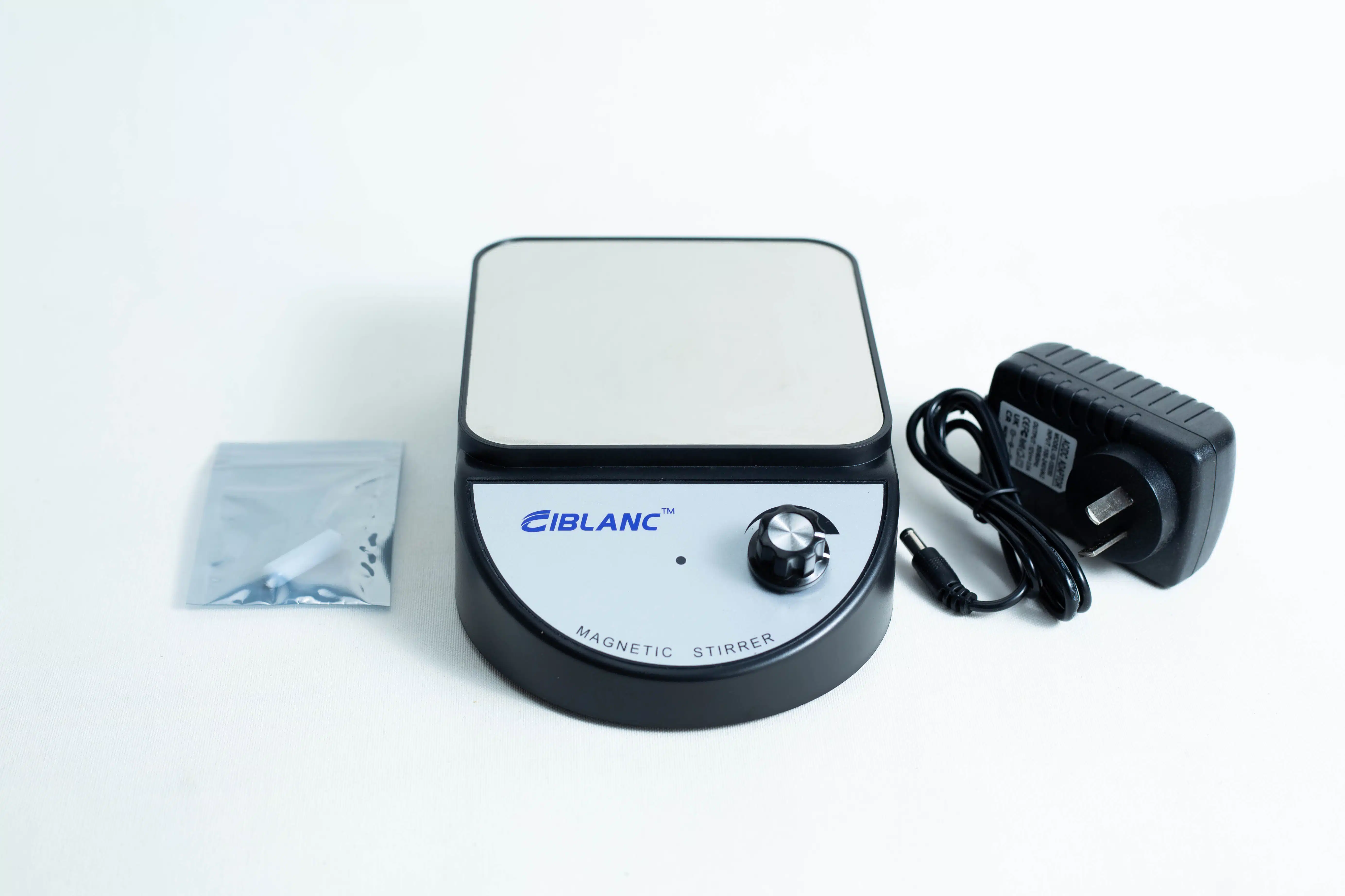 The Magnetic Stirrer Ciblanc 3500rpm, featuring a control knob, power adaptor, and accessory packet, is displayed on a white background—perfect for those seeking to purchase or upgrade their stirring machine.