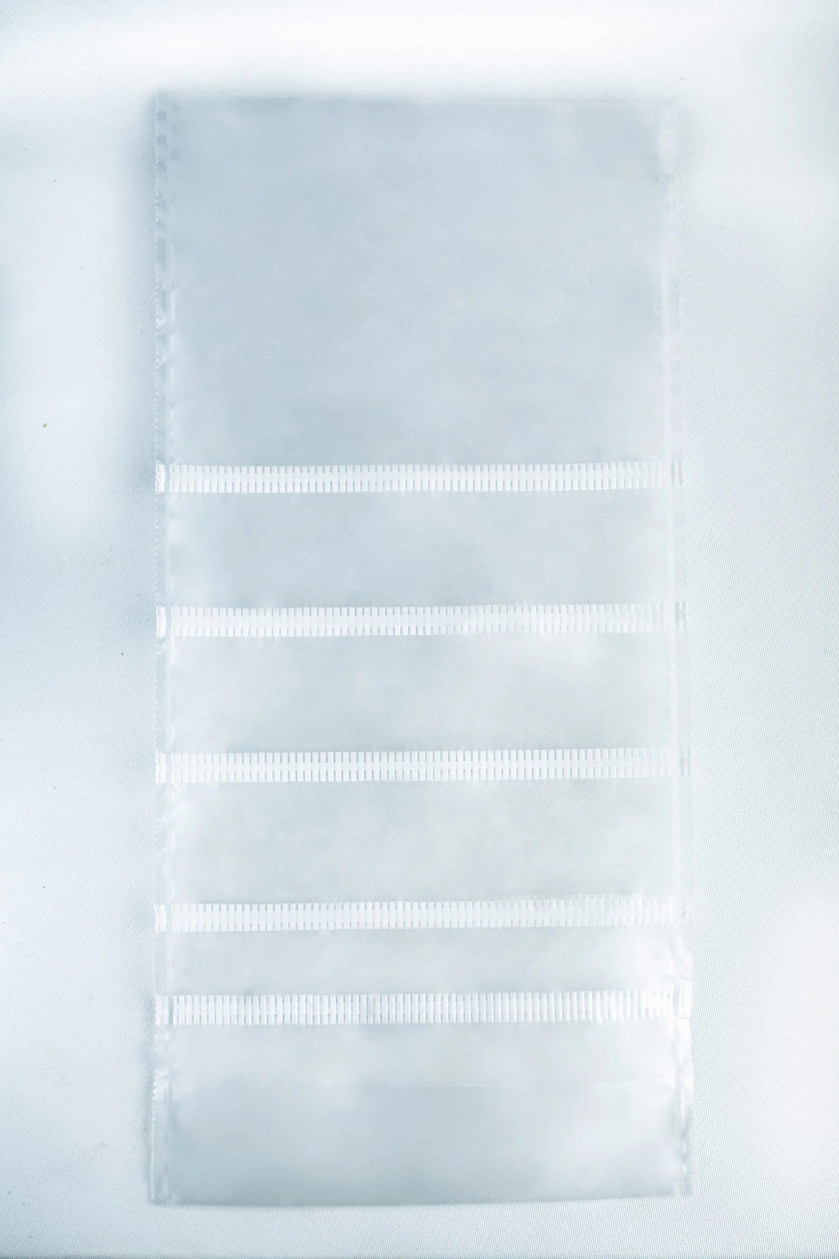 A clear plastic sheet with six horizontal pockets, ideal for organising your Mushroom Grow Bags Unicorn for spawn and substrate, set against a white background.
