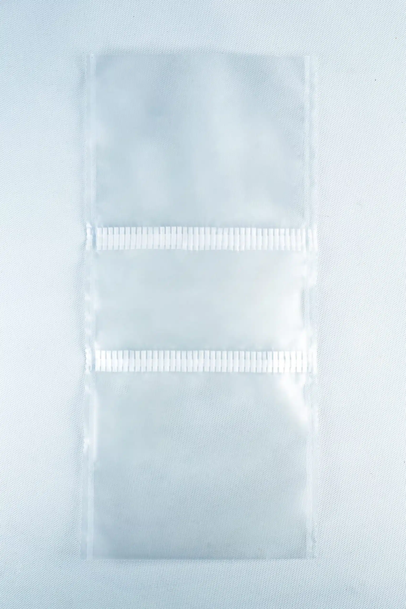 Three empty Unicorn Mushroom Grow Bags for spawn and substrate, made of transparent plastic with horizontal seals, are laid flat on a white background.