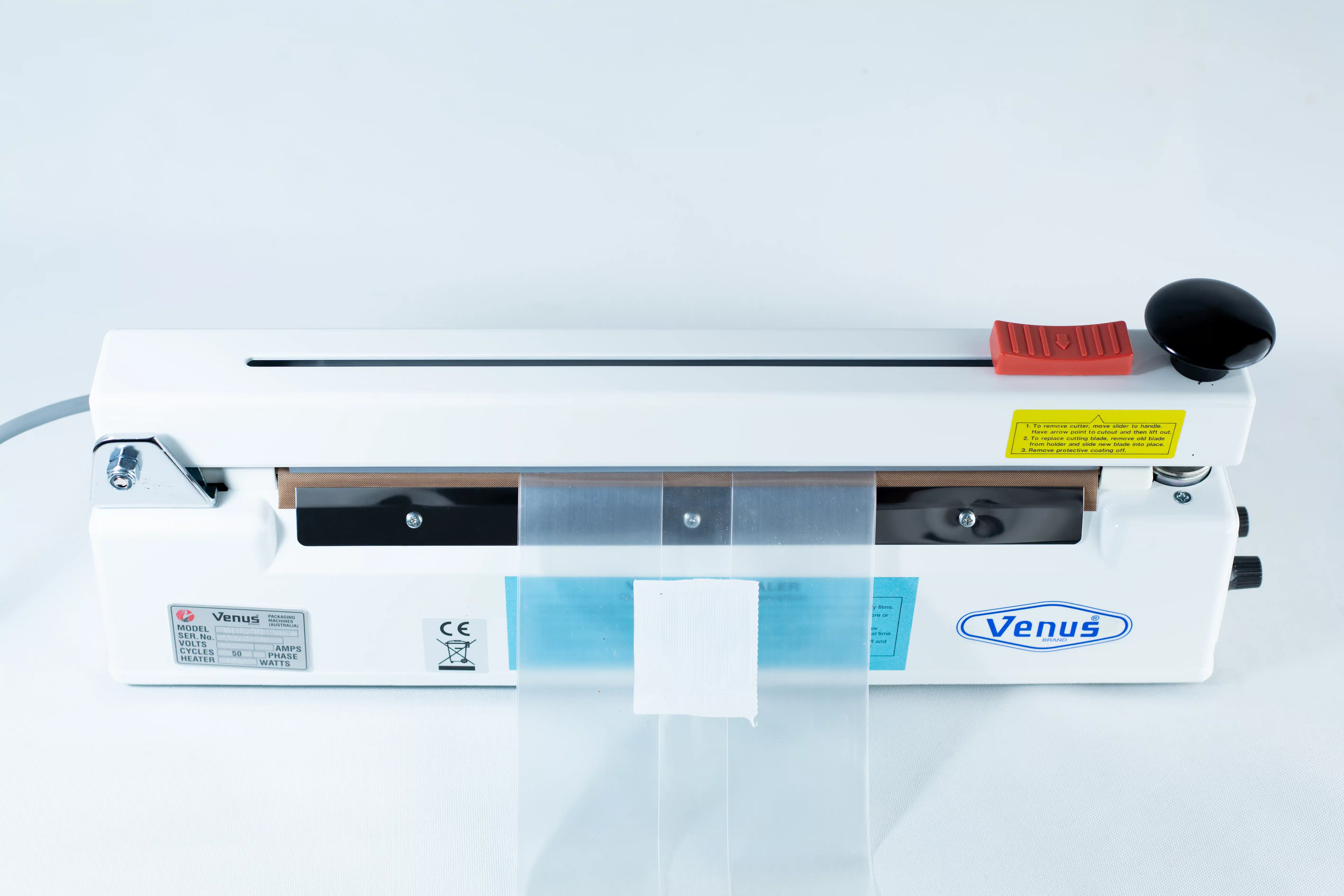 Heat Sealer 30cm Seal Width 5mm with cutter and Magnet 4 A Heat Sealer 30cm Seal Width 5mm with cutter and magnet in white is shown from above with a plastic bag placed in the sealing area.