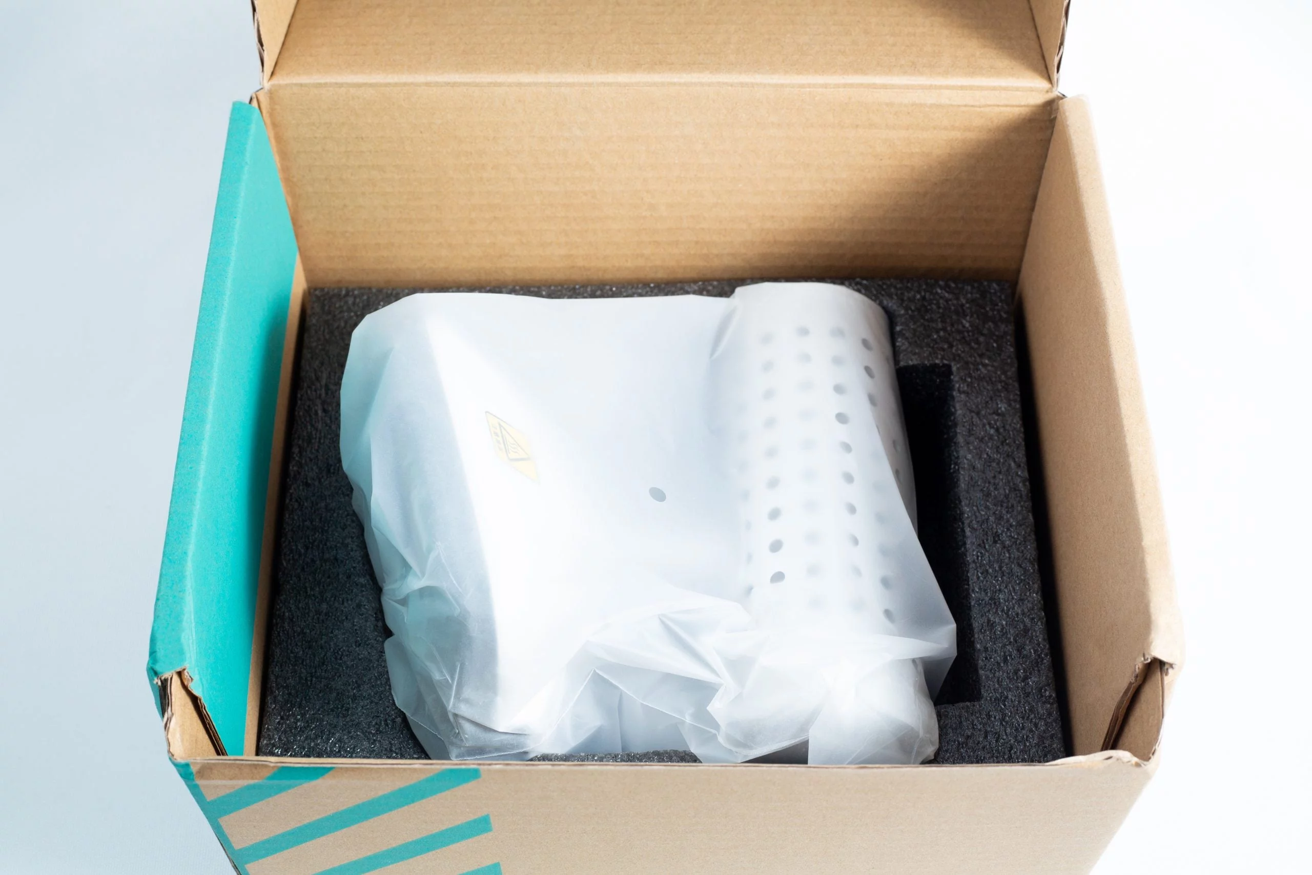 An Infrared Steriliser Bacti Cinerator Lab tool, white and wrapped in plastic, is placed inside a cardboard box with protective foam.