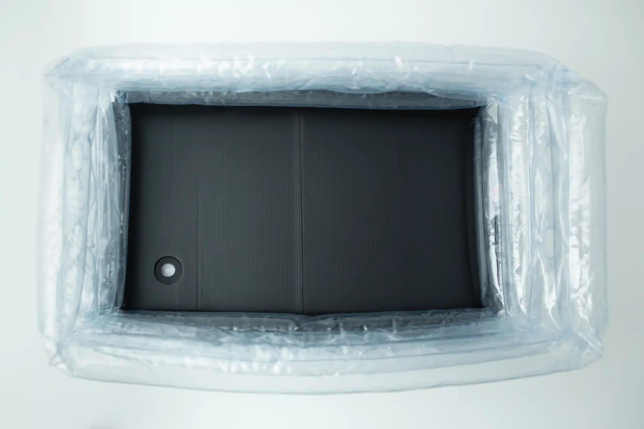 Top view of an empty inflatable monotub kit for growing mushrooms—Boomer Shroomer V 2.0—with a black rectangular base inside, resembling part of a mushroom grow kit.