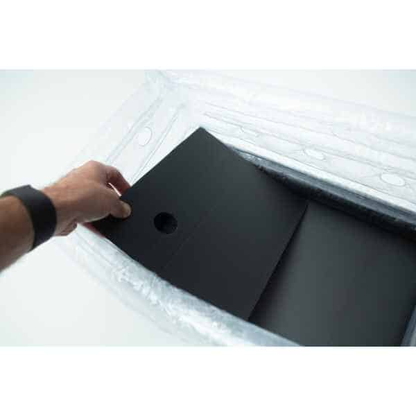A hand places a black sheet with a hole into the Boomer Shroomer V 2.0 inflatable monotub kit for growing mushrooms.