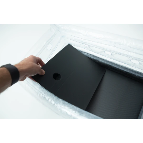 A hand places a black sheet with a hole into the Boomer Shroomer V 2.0 inflatable monotub kit for growing mushrooms.