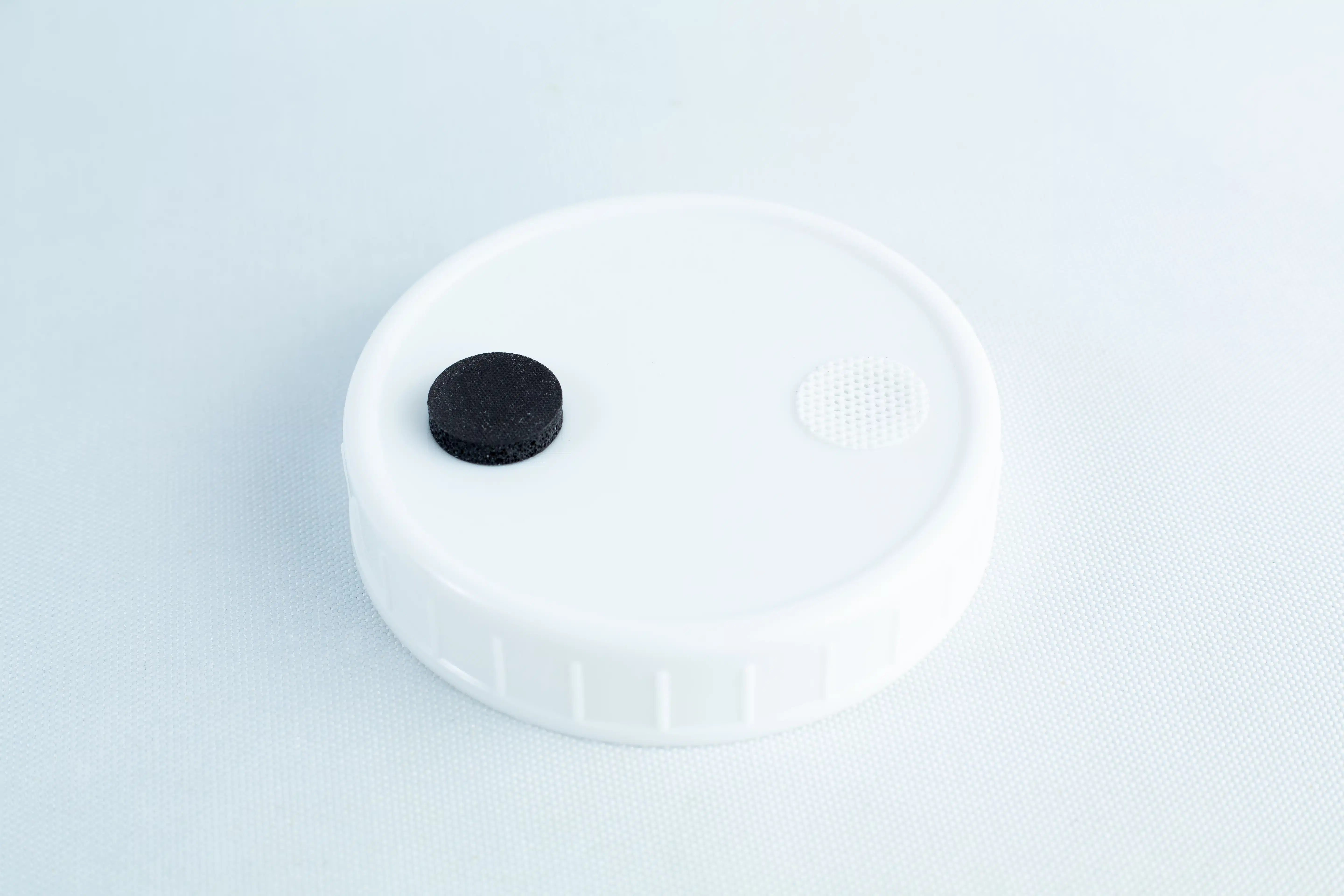 The Self-healing injection port & Air Vent Filter-3M is a white plastic lid with a black self-healing injection port and a small white air vent filter on top, shown against a light background.