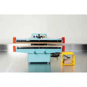 A Heat Sealer 450mm with 10mm Seal | Benchtop Model, featuring control knobs and a yellow foot pedal, sits on a metal counter, designed for reliable industrial sealing.