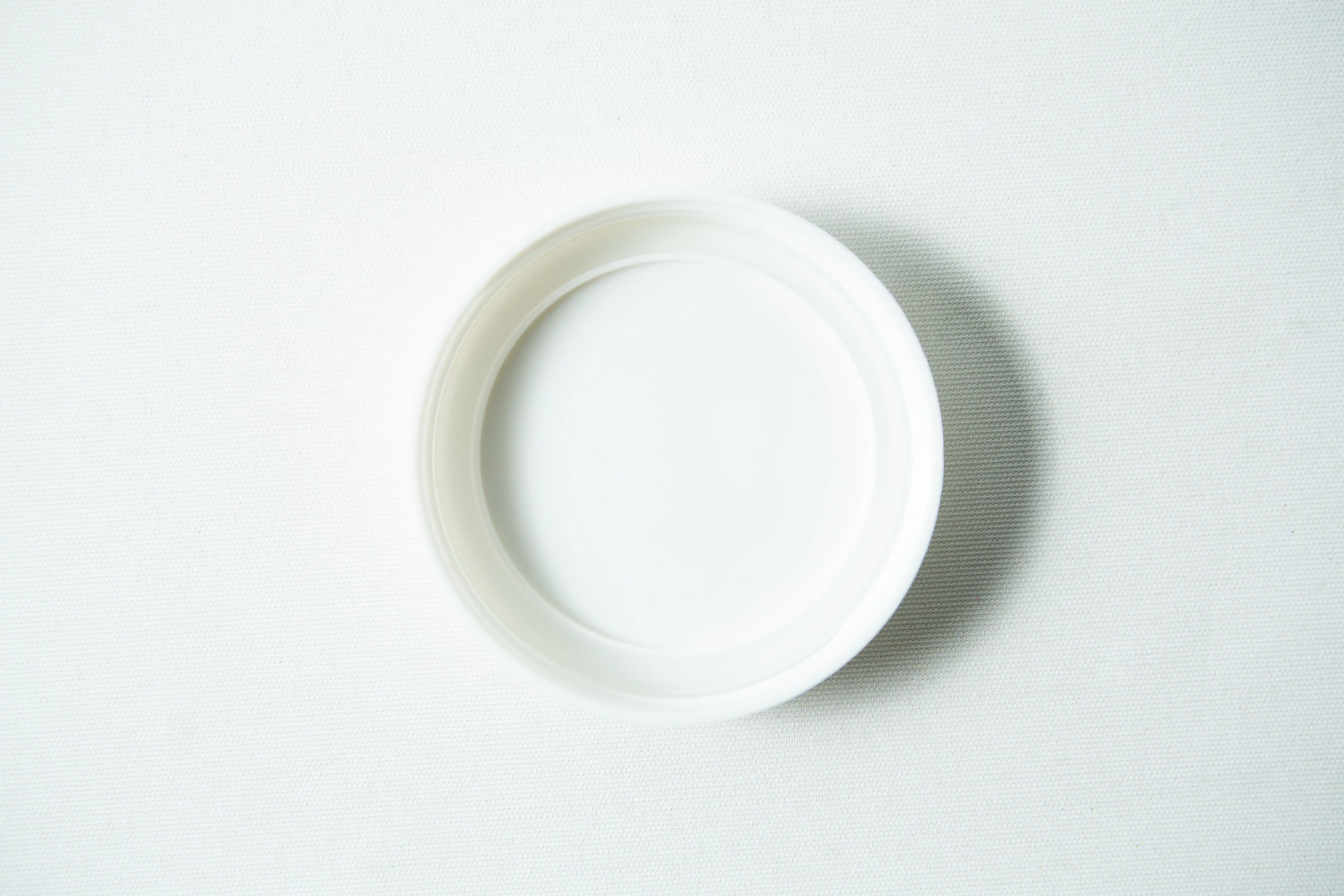 Mason Jar Lids | Wide mouth 86mm | Plain White Plastic Lids 2 A Mason Jar Lid (Plain White Plastic, Wide Mouth 86mm) from "Mason Jar Lids" rests on a lightly textured surface, viewed from above.