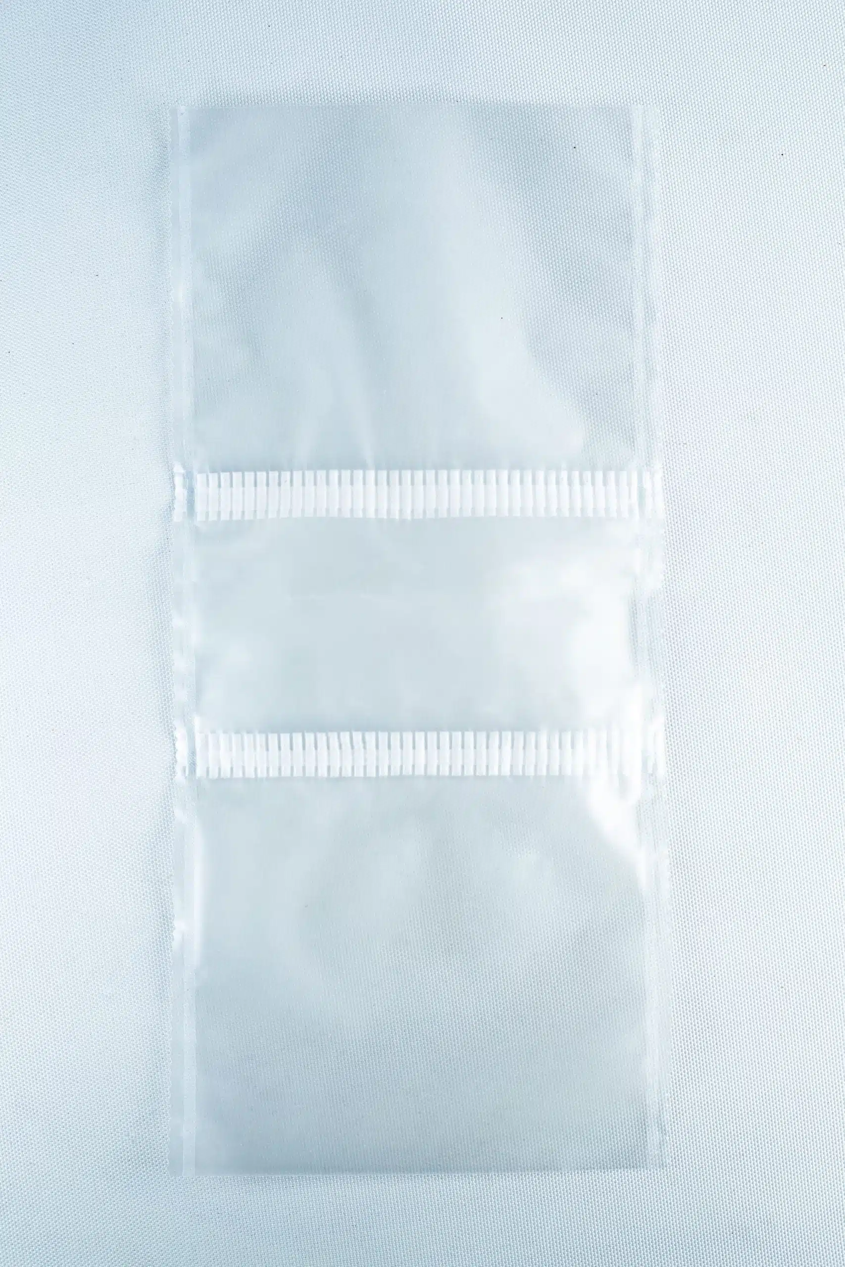 Two empty, clear Mushroom Grow Bags Unicorn for spawn and substrate are joined by a perforated line and placed on a plain white surface.