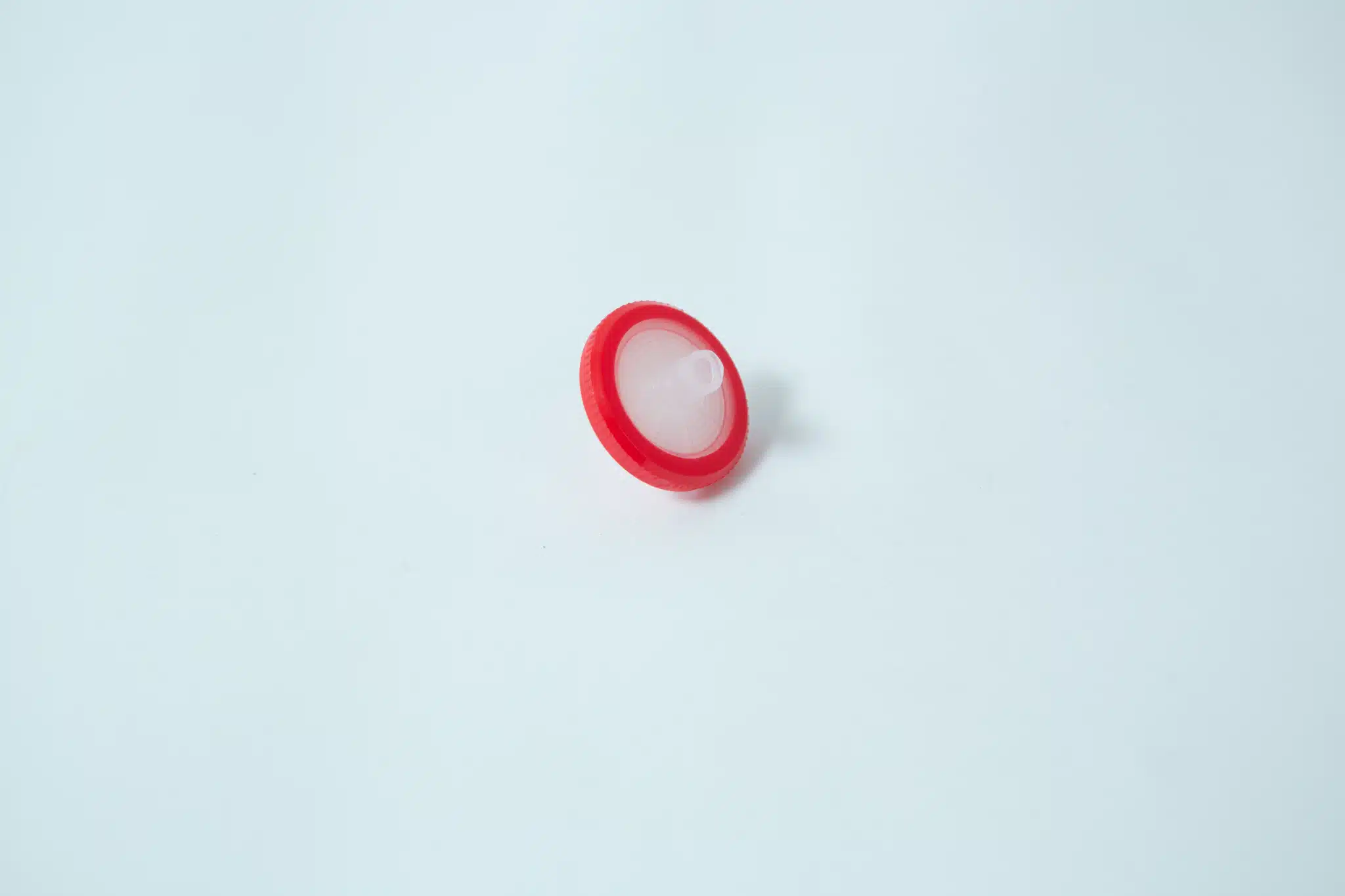 The Rubber Self-Healing Injection Port and Syringe Filter PTFE for Mycology, featuring a round red plastic body with a white centre and injection port, is displayed on a plain white background.