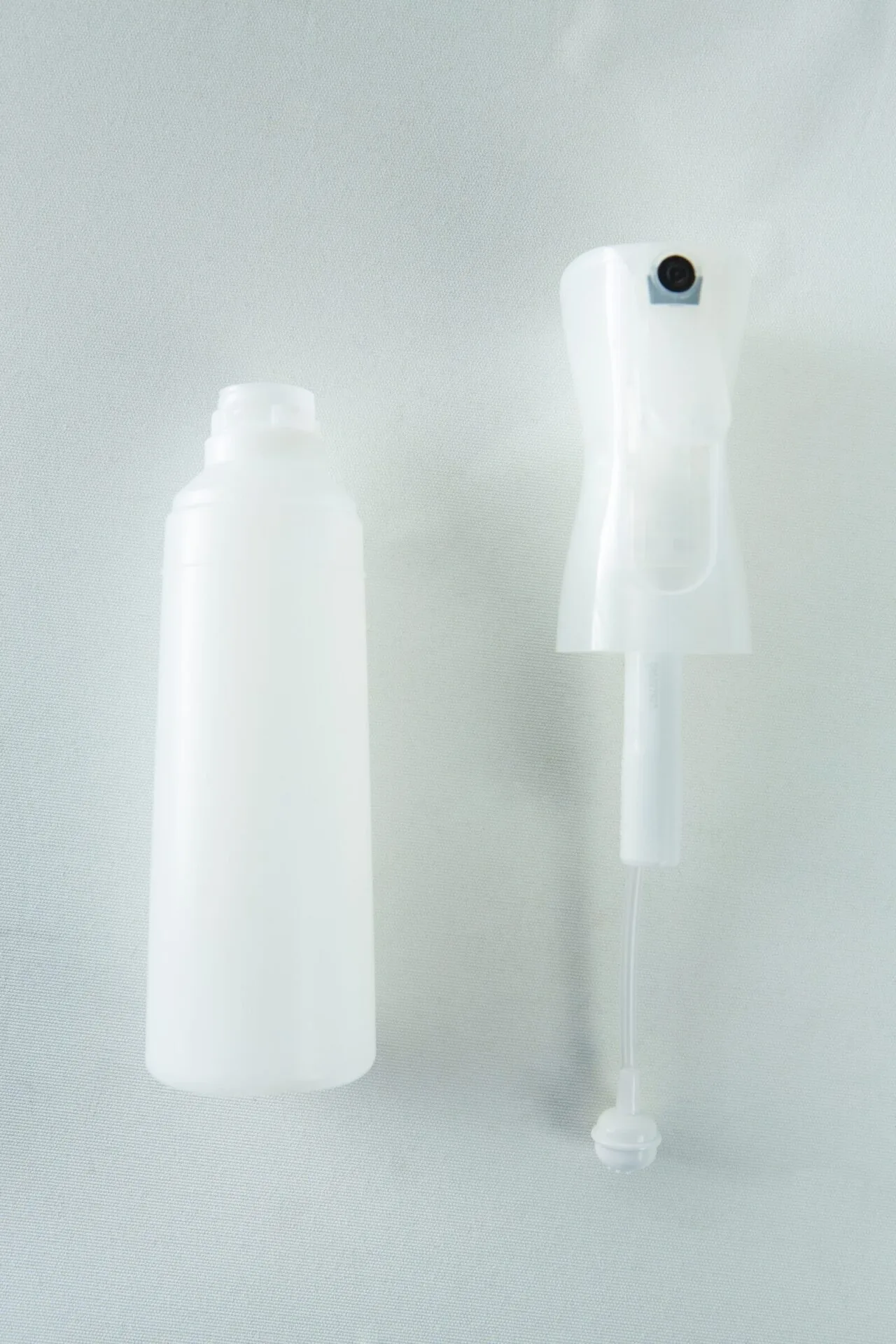 The Spray Bottle Atomiser Mushroom fine mist 300ml and a white plastic spray bottle with a trigger are set against a light background.