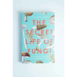 The book cover of The Secret Life of Fungi by Aliya Whiteley features delightful mushroom illustrations on a light blue background, making it a notable choice among mycology books.