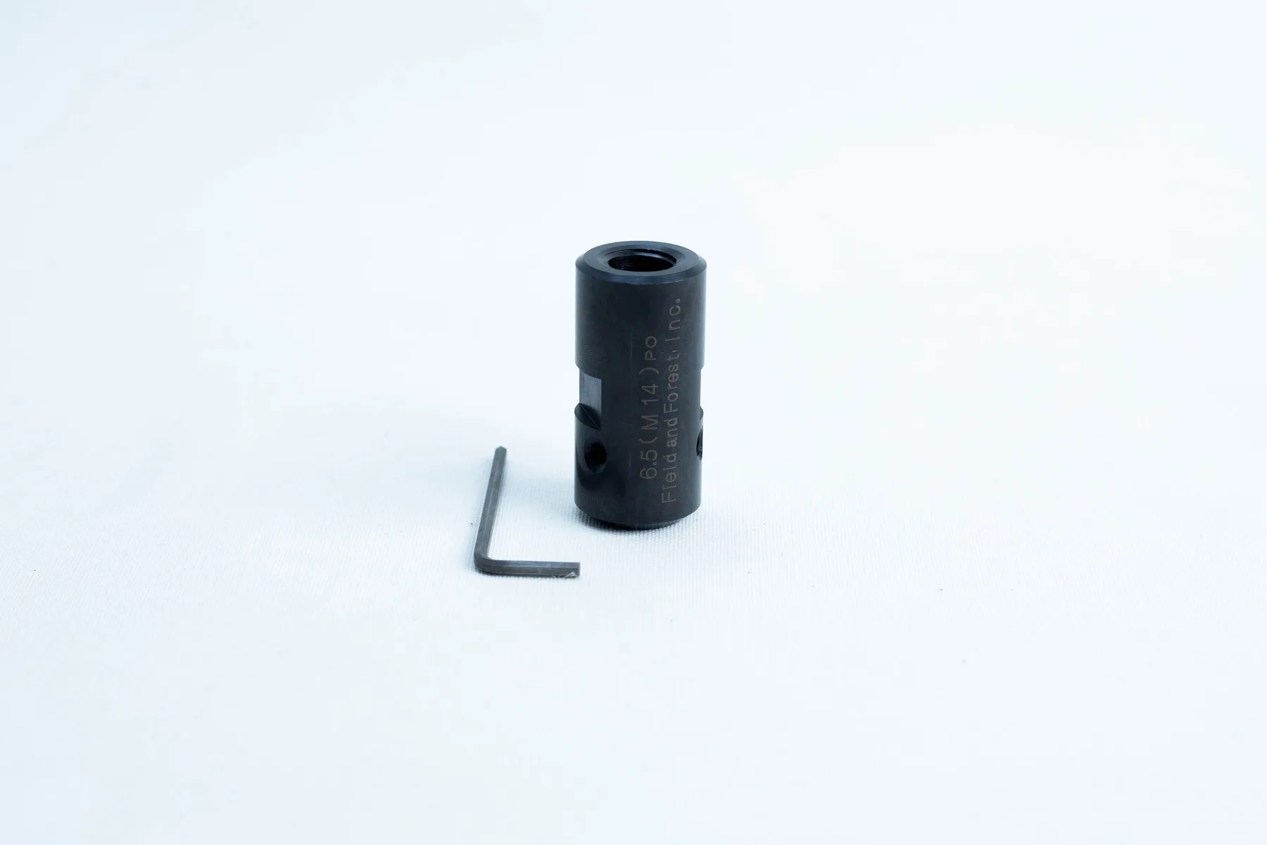 A black cylindrical metal tool and an L-shaped hex key on a white background.