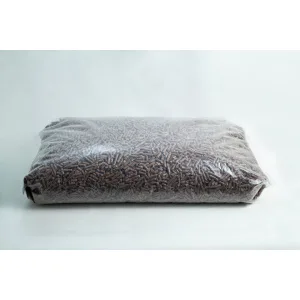 A sealed plastic bag filled with brown wood pellets on a plain white background.