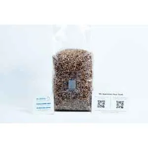 A clear bag of rye grain organic pre-sterilised for mushroom cultivation with injection port and air-filter is shown with two business cards in front on a white background.