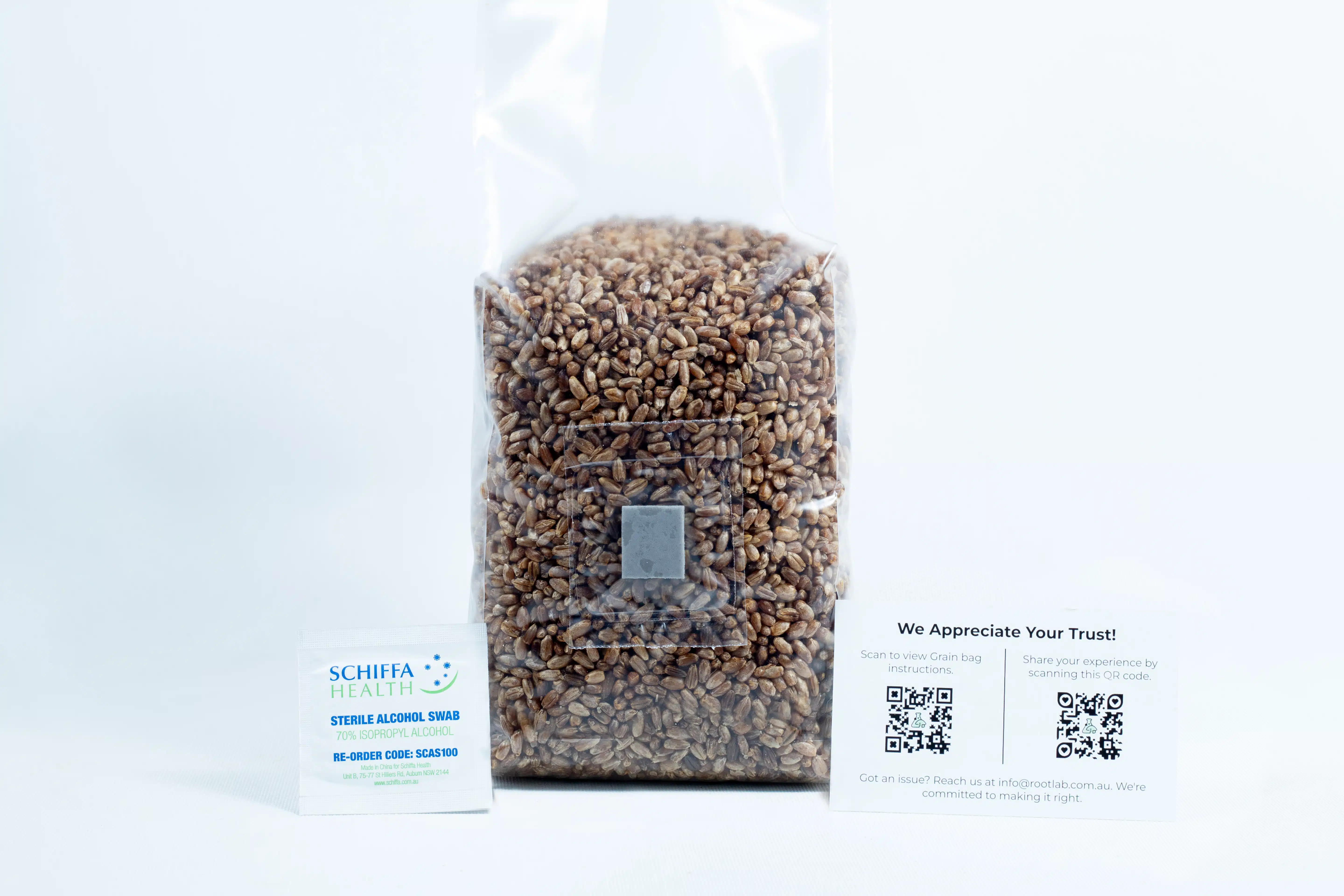 A clear bag of rye grain organic pre-sterilised for mushroom cultivation with injection port and air-filter is shown with two business cards in front on a white background.