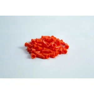 A pile of small, orange plastic caps on a white surface.