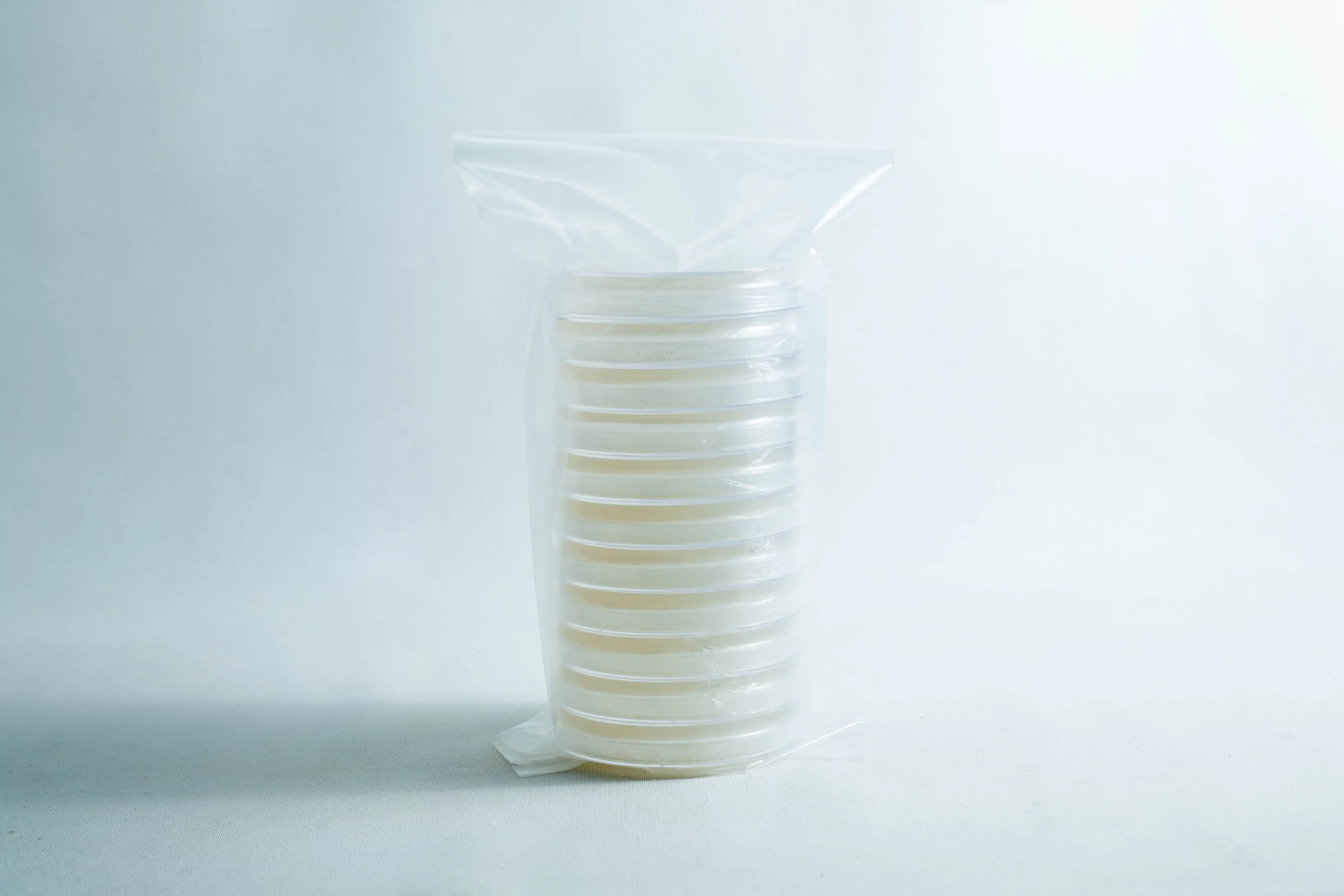 Sterile Water Agar Petri Dishes (WA) x10 with Parafilm 3 A stack of clear petri dishes wrapped in a plastic bag on a plain white background.