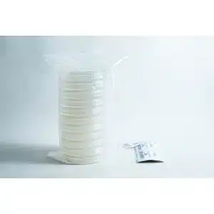A stack of sealed petri dishes and a small packet on a white surface with a plain background.