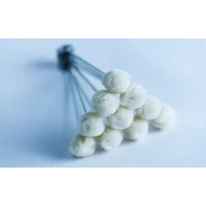 A cluster of white cotton buds arranged in a triangular formation on a light surface.