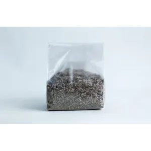 A clear plastic bag filled with sand and small pebbles, set against a plain white background.