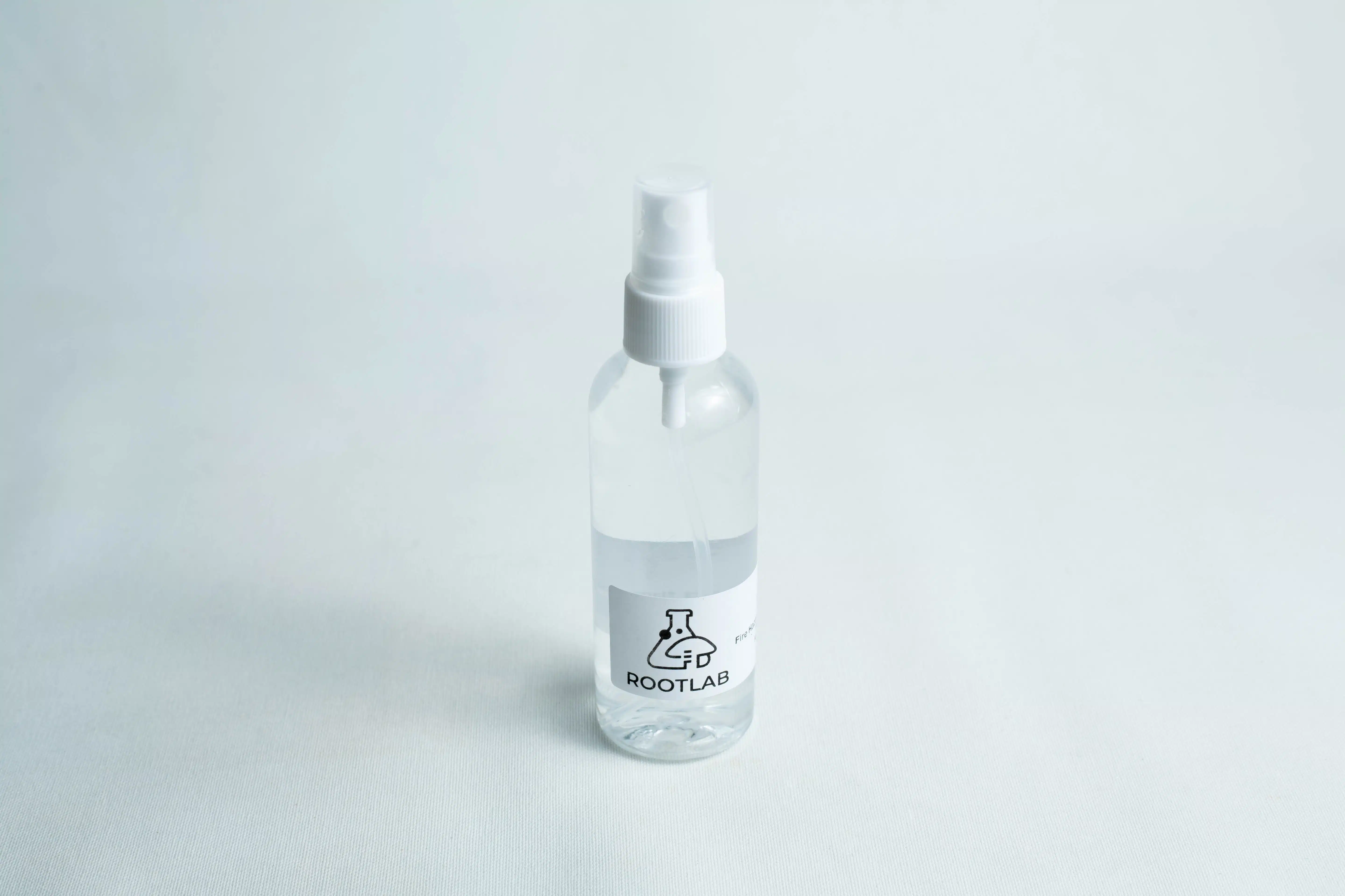 Clear plastic spray bottle labelled ROOTLAB filled with liquid, ideal for use with your Monotub Mushroom Growing Kit-Premium, shown on a white surface.