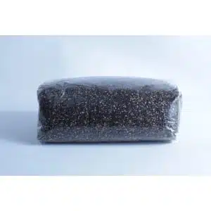 Melbourne 9 A block of dark soil or compost, perfect for the Monotub Mushroom Growing Kit-Premium, is wrapped in clear plastic and set against a plain light background.