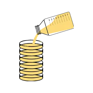 A bottle pours yellow liquid into a stack of round glass tumblers.