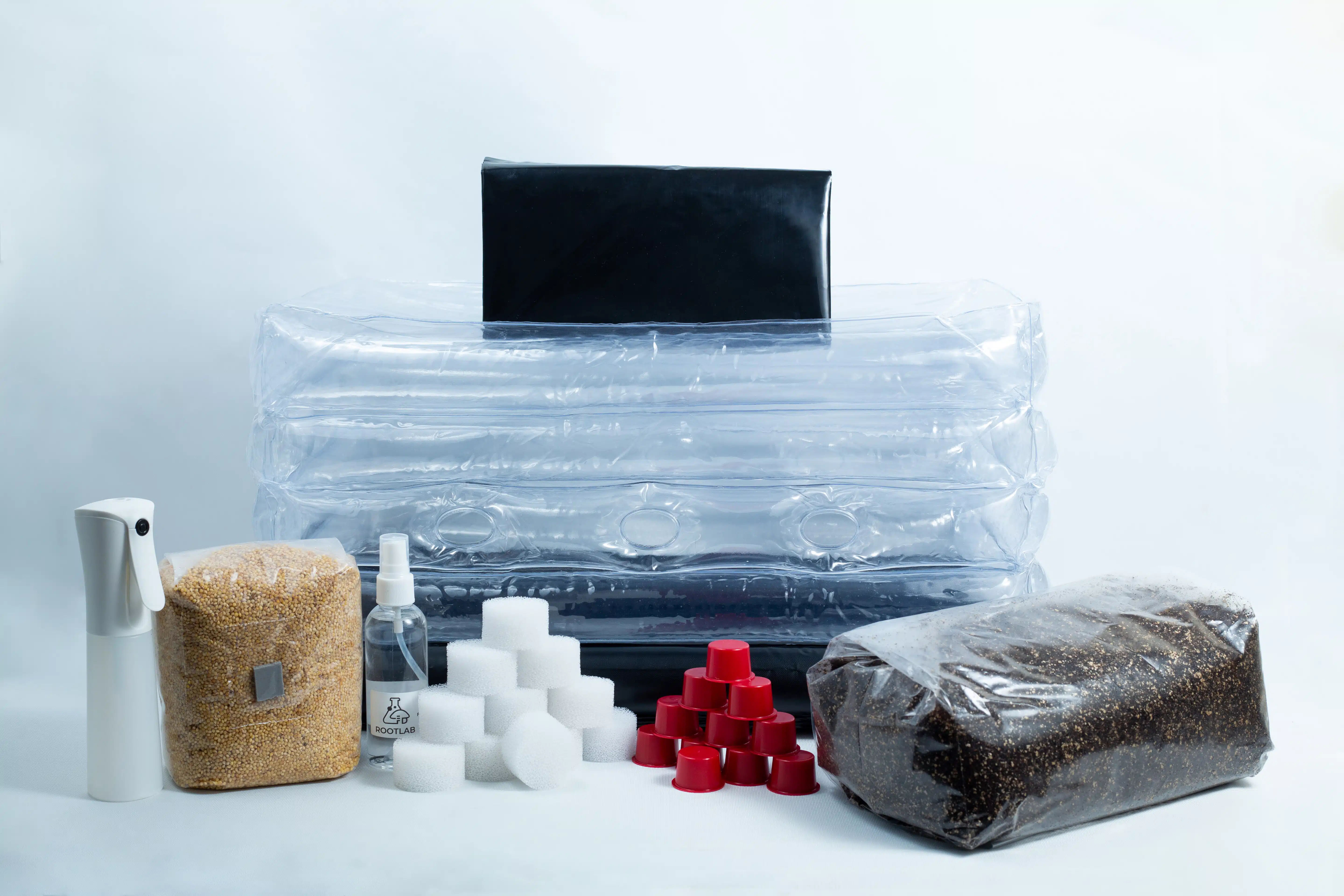 Monotub Mushroom Growing Kit-Premium 1 Mushroom growing kit with a plastic tent, substrate bag, spray bottle, sponges, and red caps.