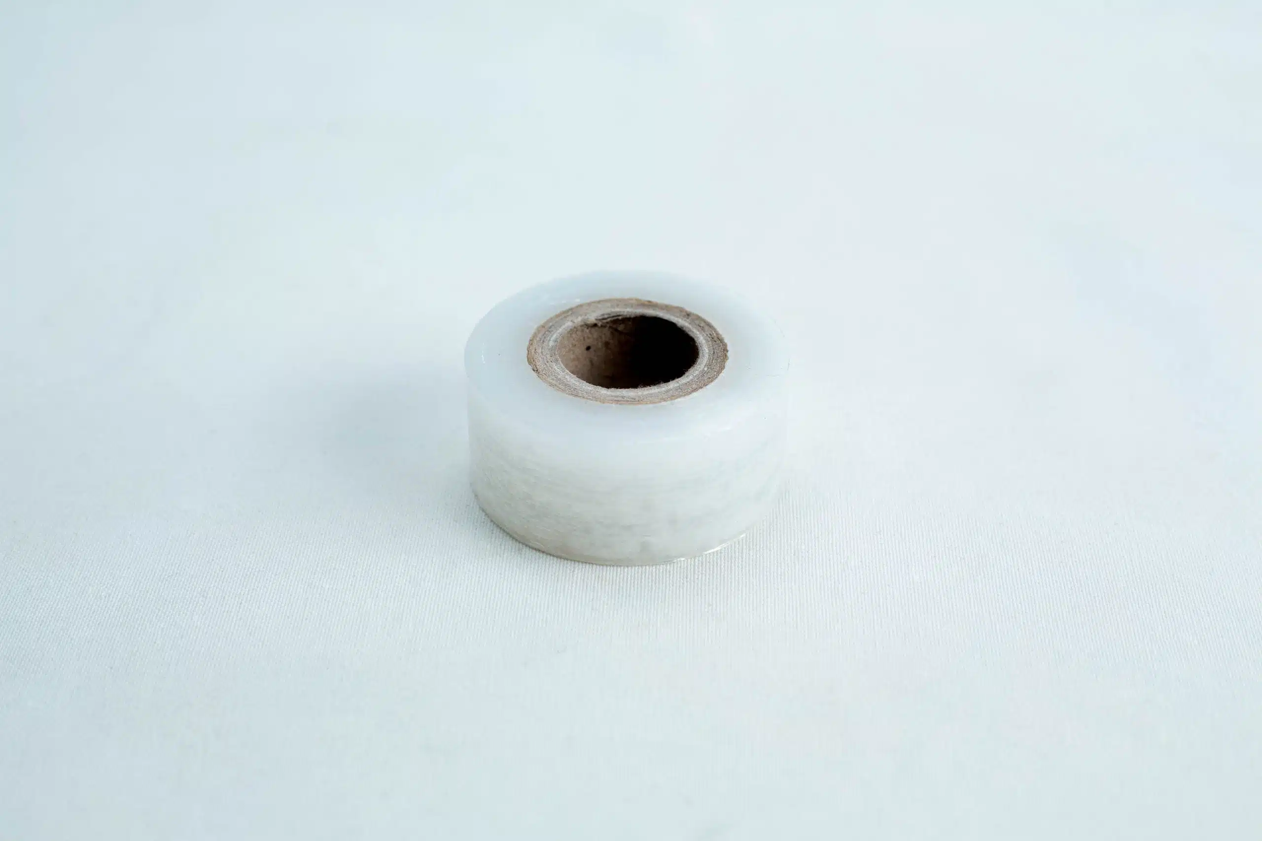 A single roll of "Grafting Tape to seal agar plates or for plant grafting" rests on a plain white surface, perfect for sealing agar plates or use in plant grafting.