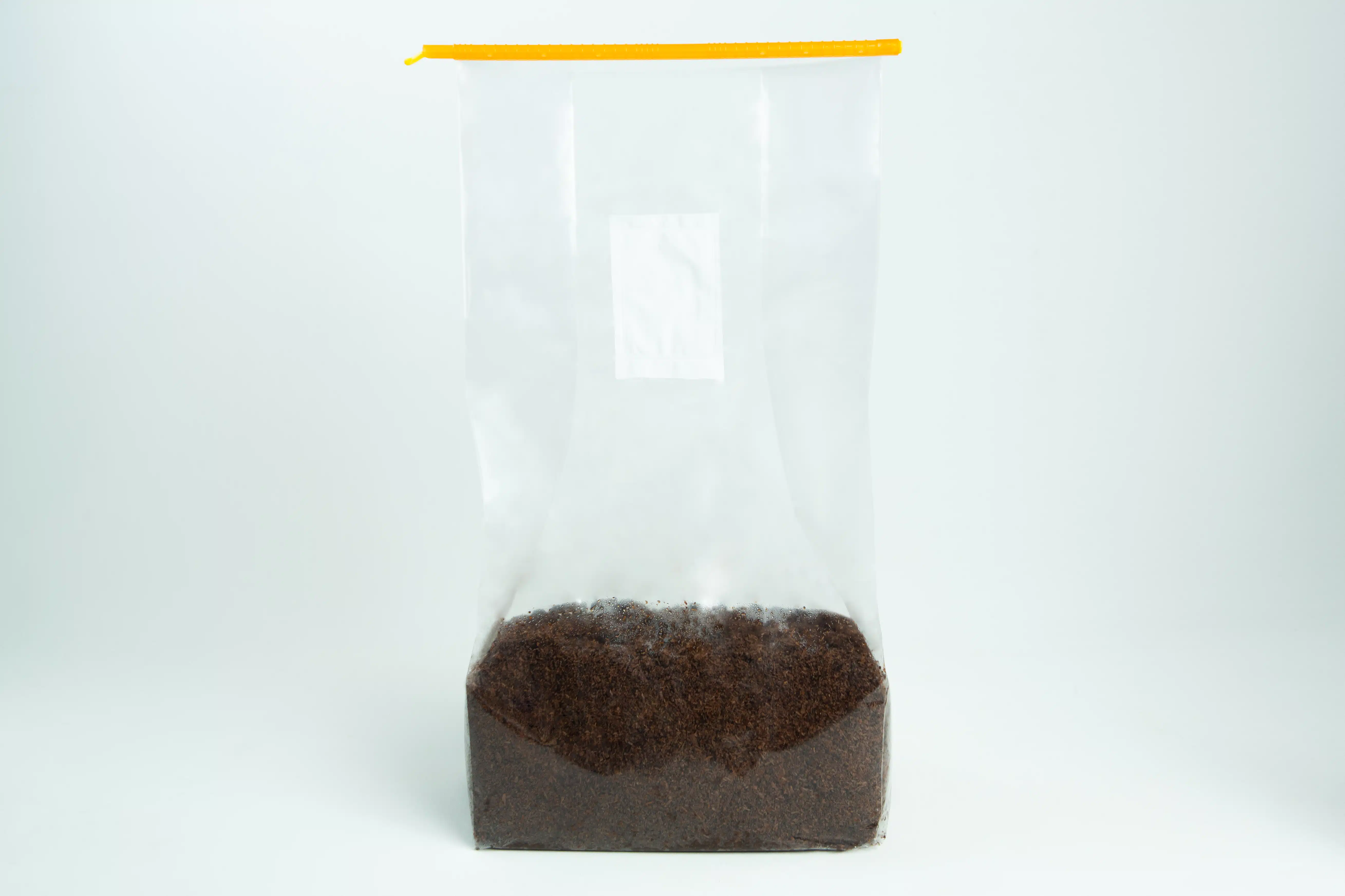 Clear plastic bag with a yellow zip, partially filled with loose black tea leaves.