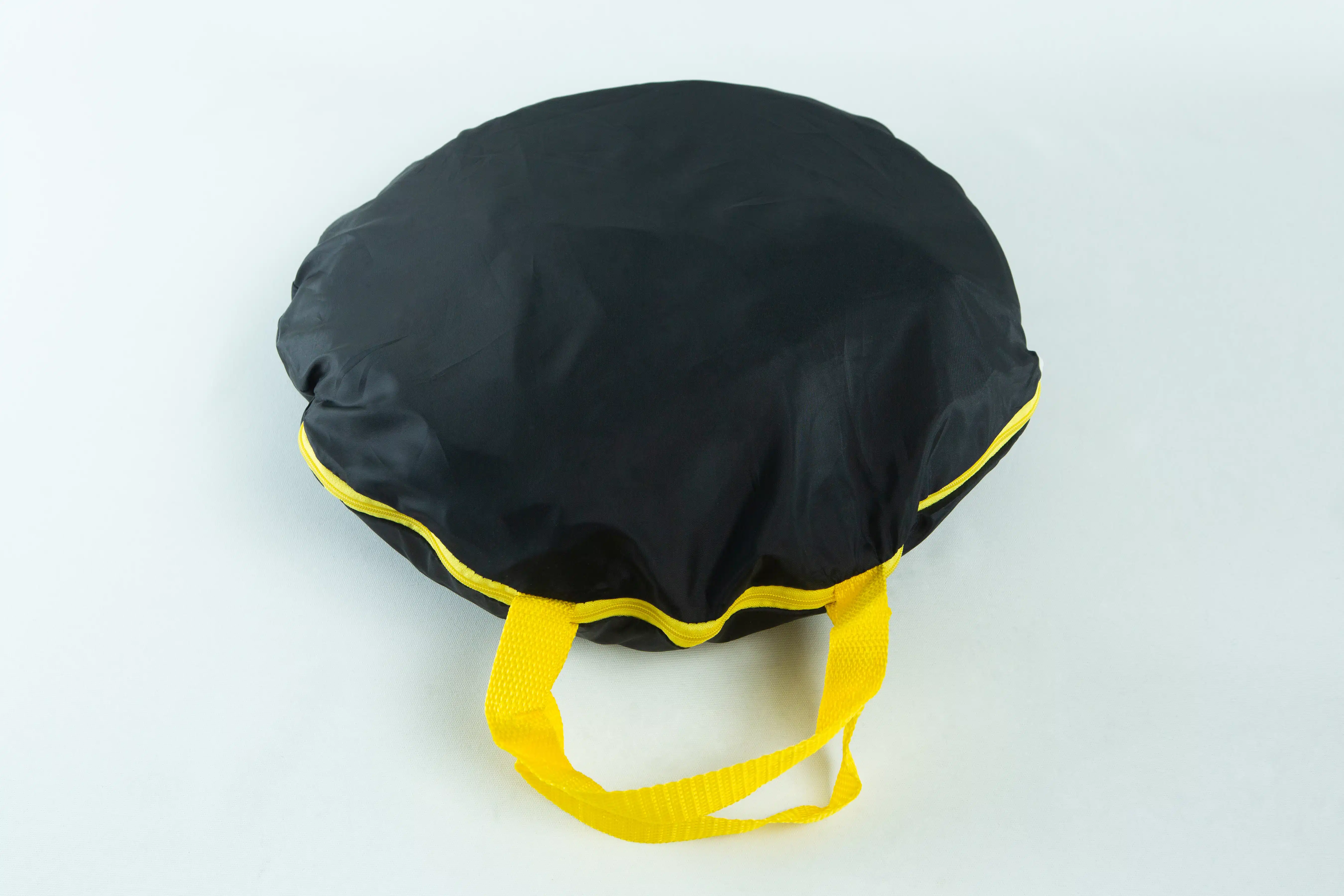 A black circular bag with yellow handles and trim, placed on a white background.