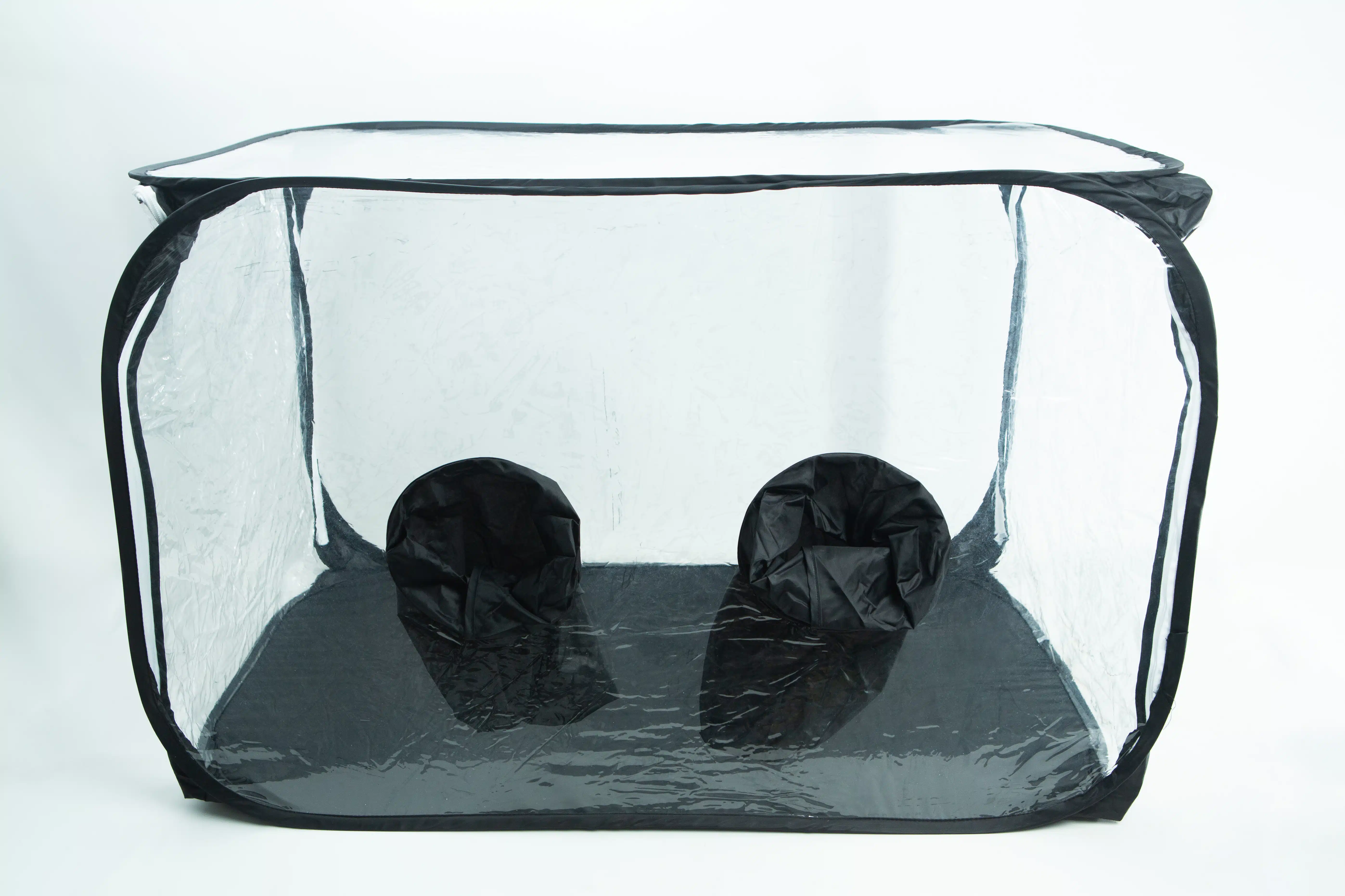 Clear pop-up box with two black fabric sleeves on the bottom panel, used for handling items inside safely.