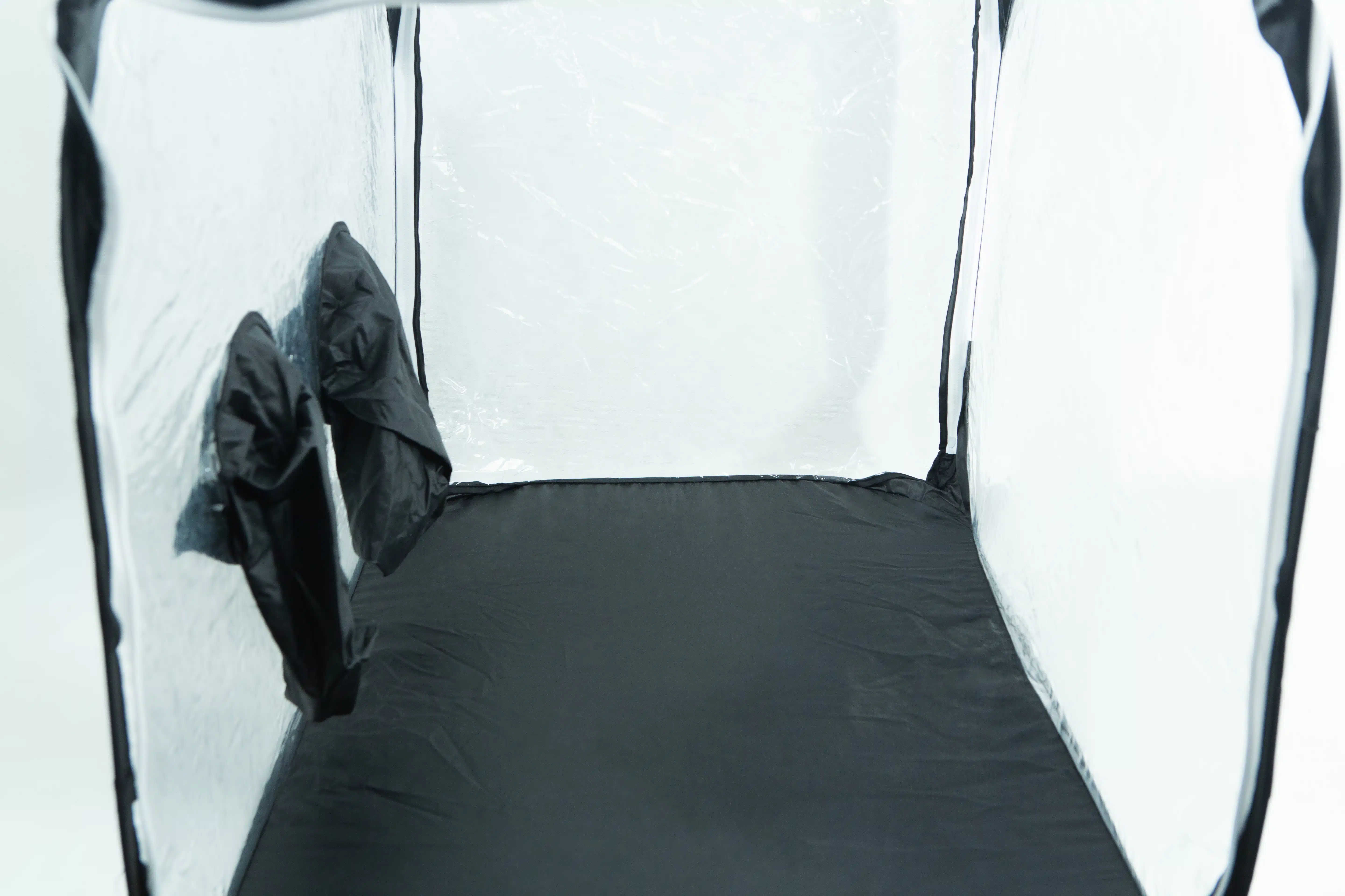 Interior of an empty grow tent with reflective walls and two vents on the left side.