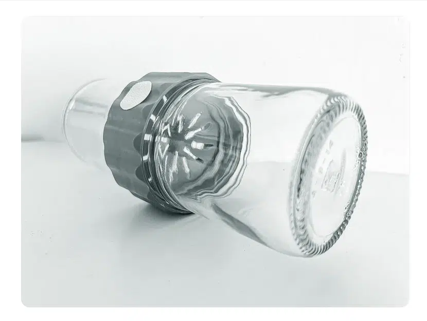 A Plant Cell Biocoupler™ Glass Set (16oz, 12oz, 8oz) glass is placed upside down over a citrus juicer reamer on a white surface.