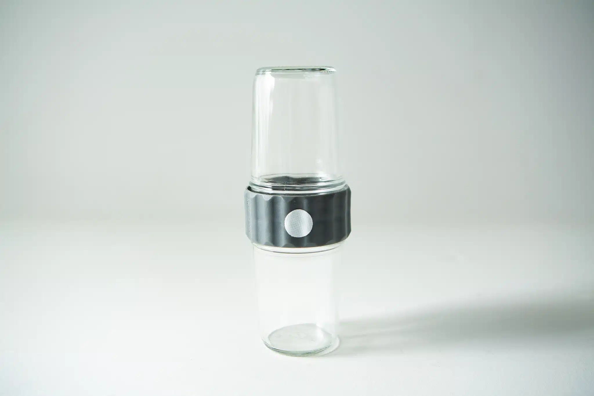 The Plant Cell Biocoupler™ Glass Set (454ml, 340ml, 227ml) features two transparent glass tumblers stacked with a grey ribbed connector around their middles, shown against a white background.