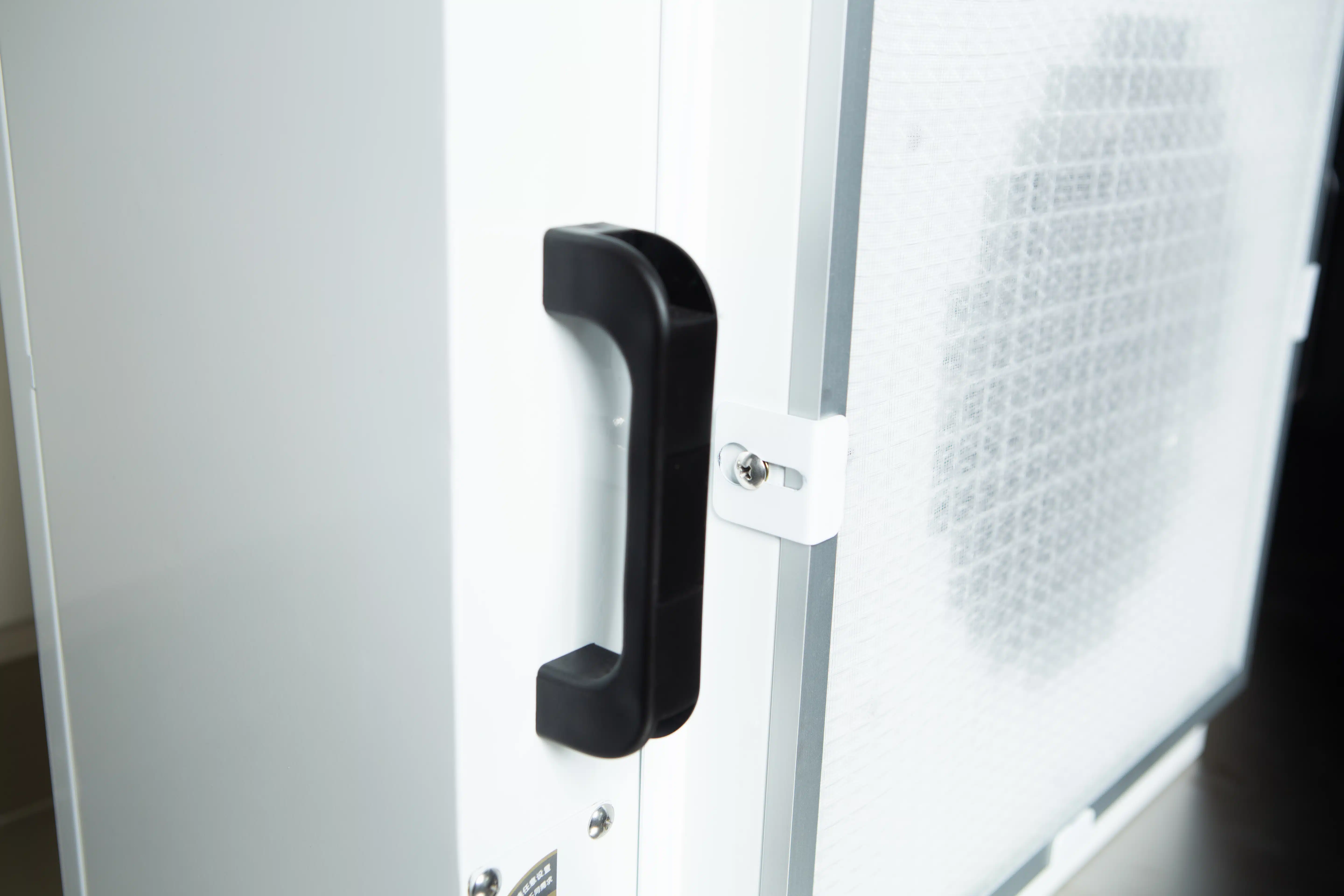 Laminar Flow Hood H14 w/prefilter 120x60x35cm 2 Close-up of a black handle on the Laminar Flow Hood H14 w/prefilter (120x60x35cm), a white rectangular device with a mesh filter panel.