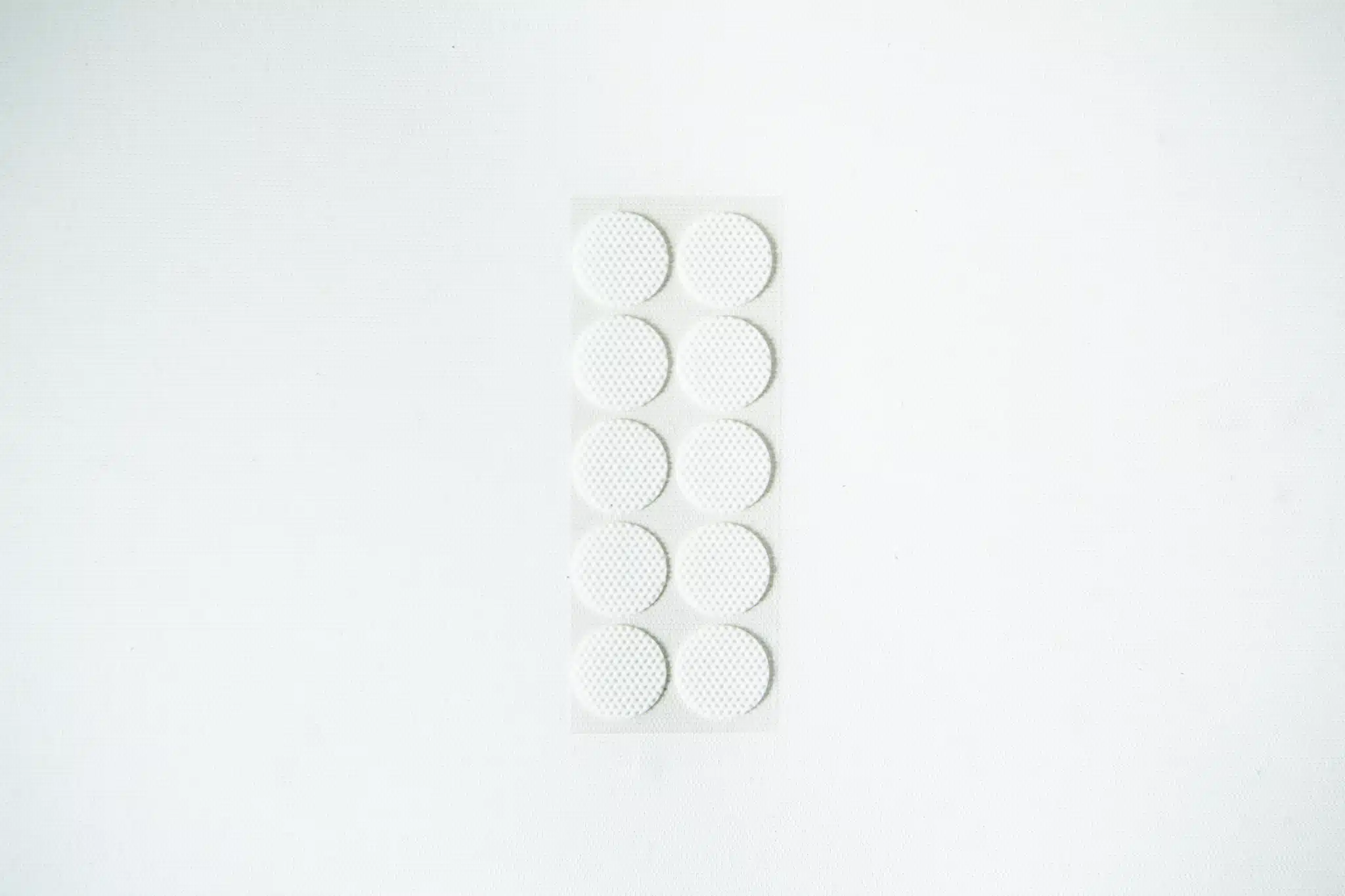 A blister pack containing ten round, white tablets on a plain white background.