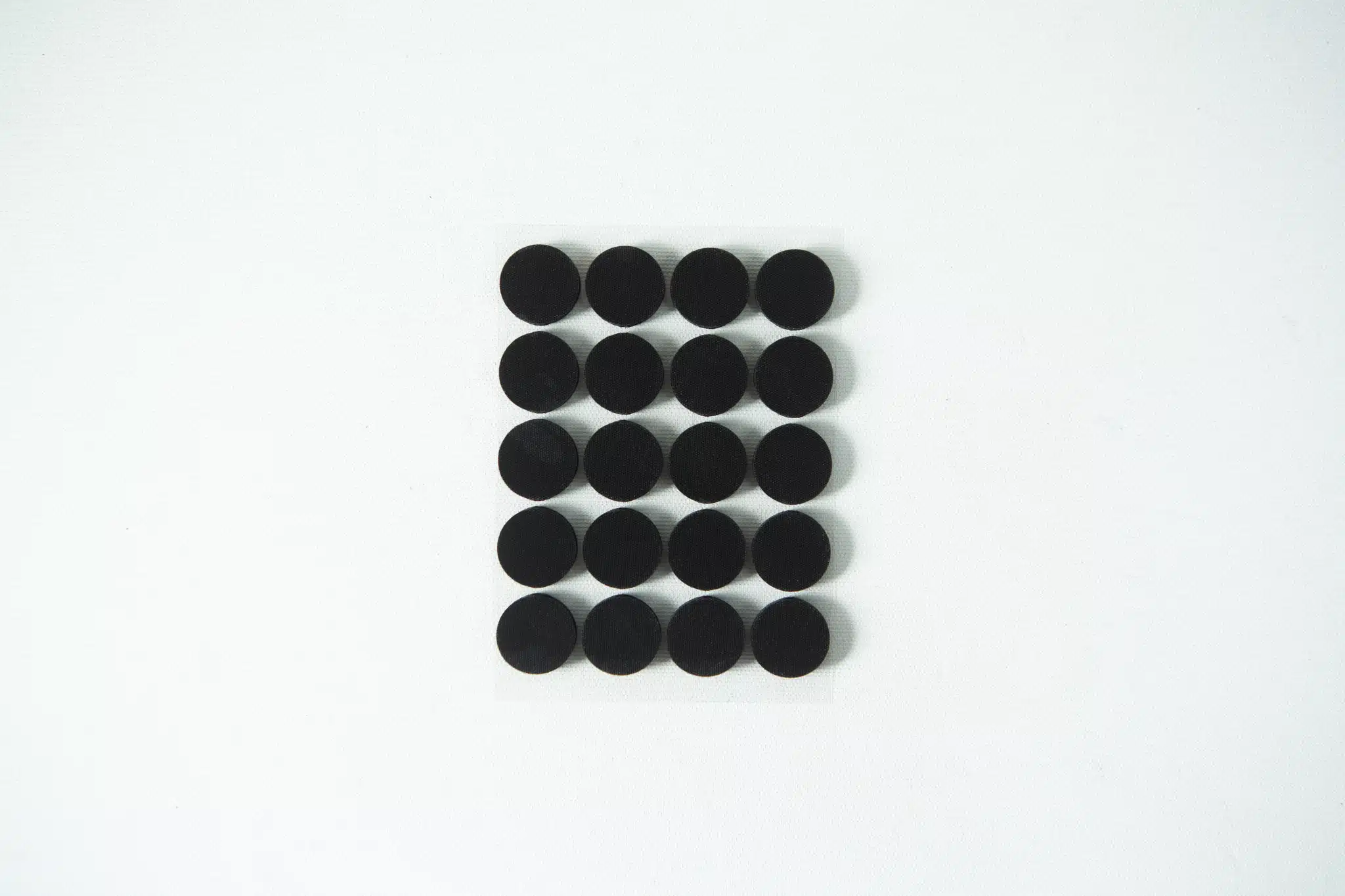 Twenty black circular dots arranged in a 4 by 5 grid on a white background.