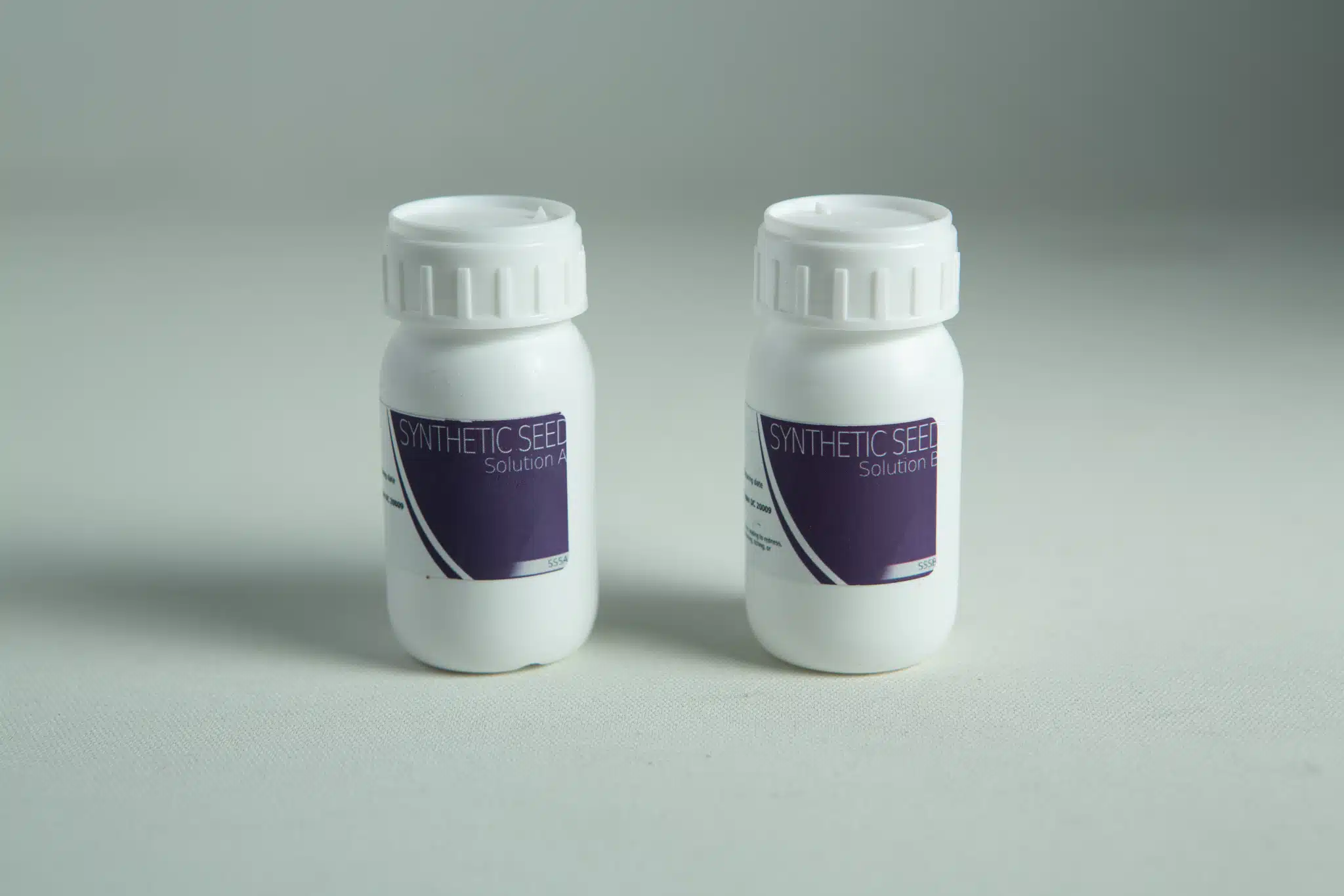 Two white bottles labelled Solution A and Solution B from the Plantcell Synthetic Seed Starter Kit are displayed on a light background.