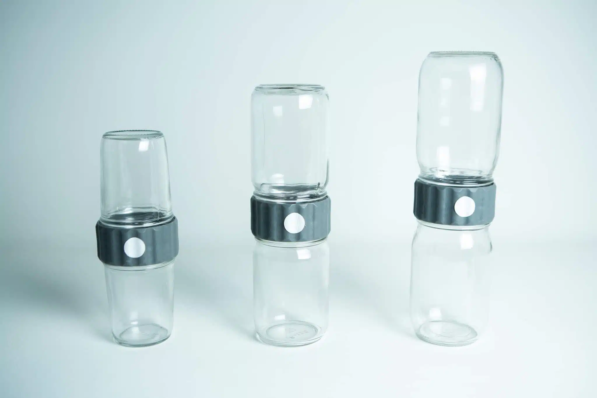 Three stacked pairs of Plant Cell Biocoupler™ Glass jars (454ml, 340ml, 227ml) joined by black lids with white buttons, arranged from left to right.