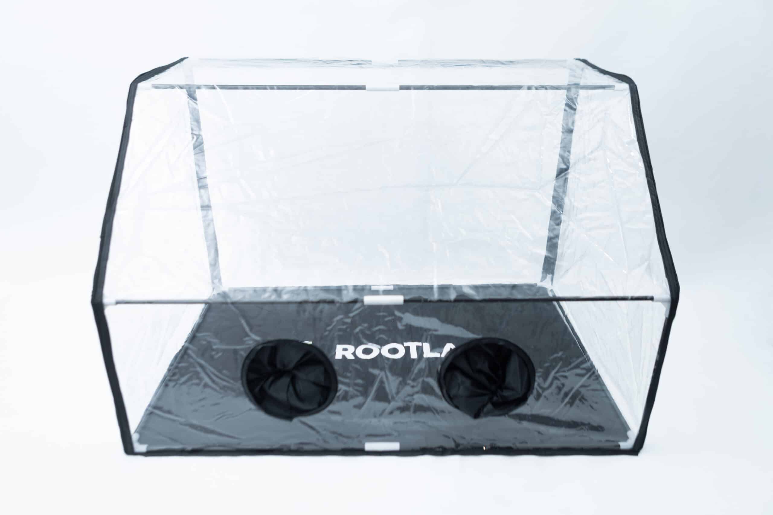 Rootlab Still Air Box with viewing Window Angled 1 The Rootlab Still Air Box with Viewing Window Angled features clear plastic construction, two circular openings, a convenient viewing window, and ROOTLA branding on its black base. It’s perfect for use as a still air box or Rootlab environment for your plants.